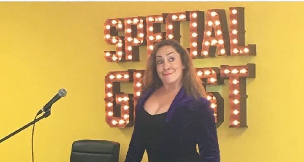 CarOlé Flamenco waist-up on a comedy stage with SPECIAL GUEST marquee lights