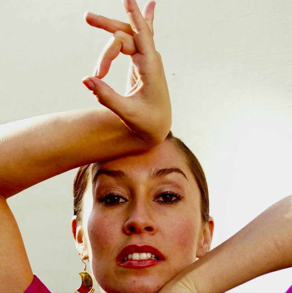 Color portrait of CarOlé Flamenco with her hands framing her face
